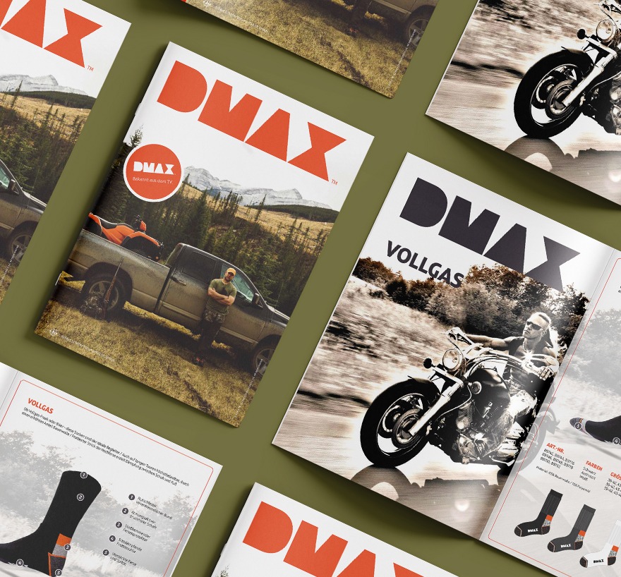 Versetzt angeordnete offene Seiten der Broschueren des DMAX Kollektions Katalog von der Schaefer Strumpffabrik. Zusehen ist die Titelseite mit einem Truck vor einem Wald und einem Motorrad Bild zum Artikel „Vollgas“ und Socken gehörend zu dem Artikel. Liegend auf einem olivgruenen Untergrund.